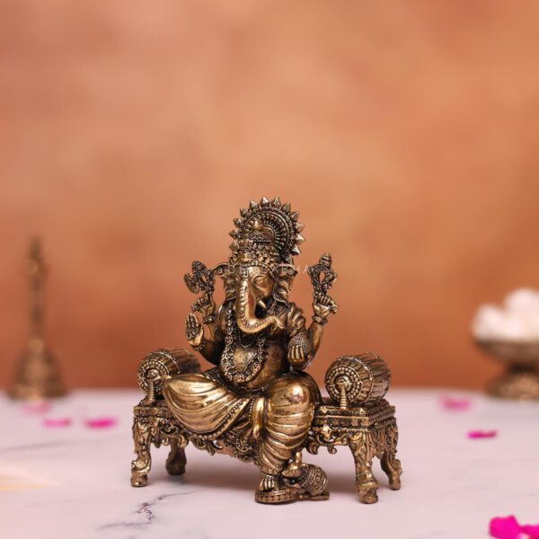 Brass ganesh statue sitting on sofa
