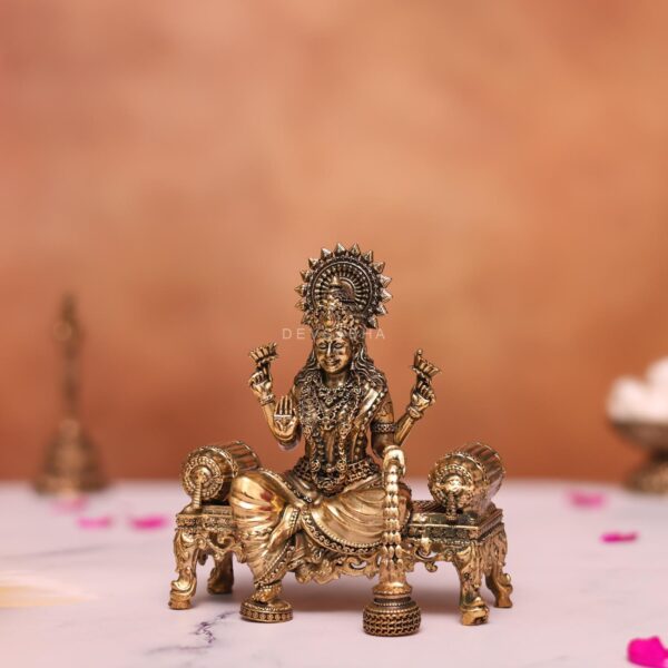 Brass laxmi statue sitting on sofa